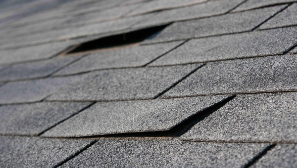 lifted roof shingles from past wind and storm damage, causing need for Houston roof repairs
