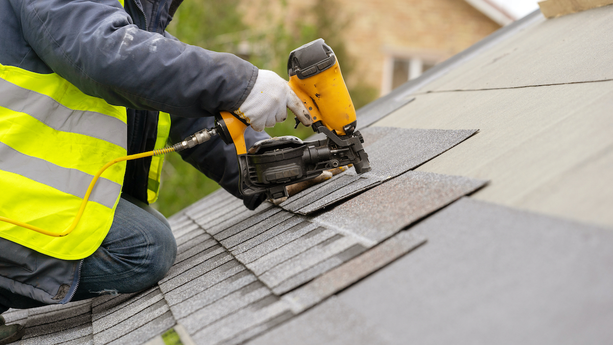 Roofing contractor installing roof shingles correctly during Friendswood roof replacement