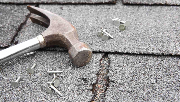Sugar Land roof with signs of damage, hammer, and nails