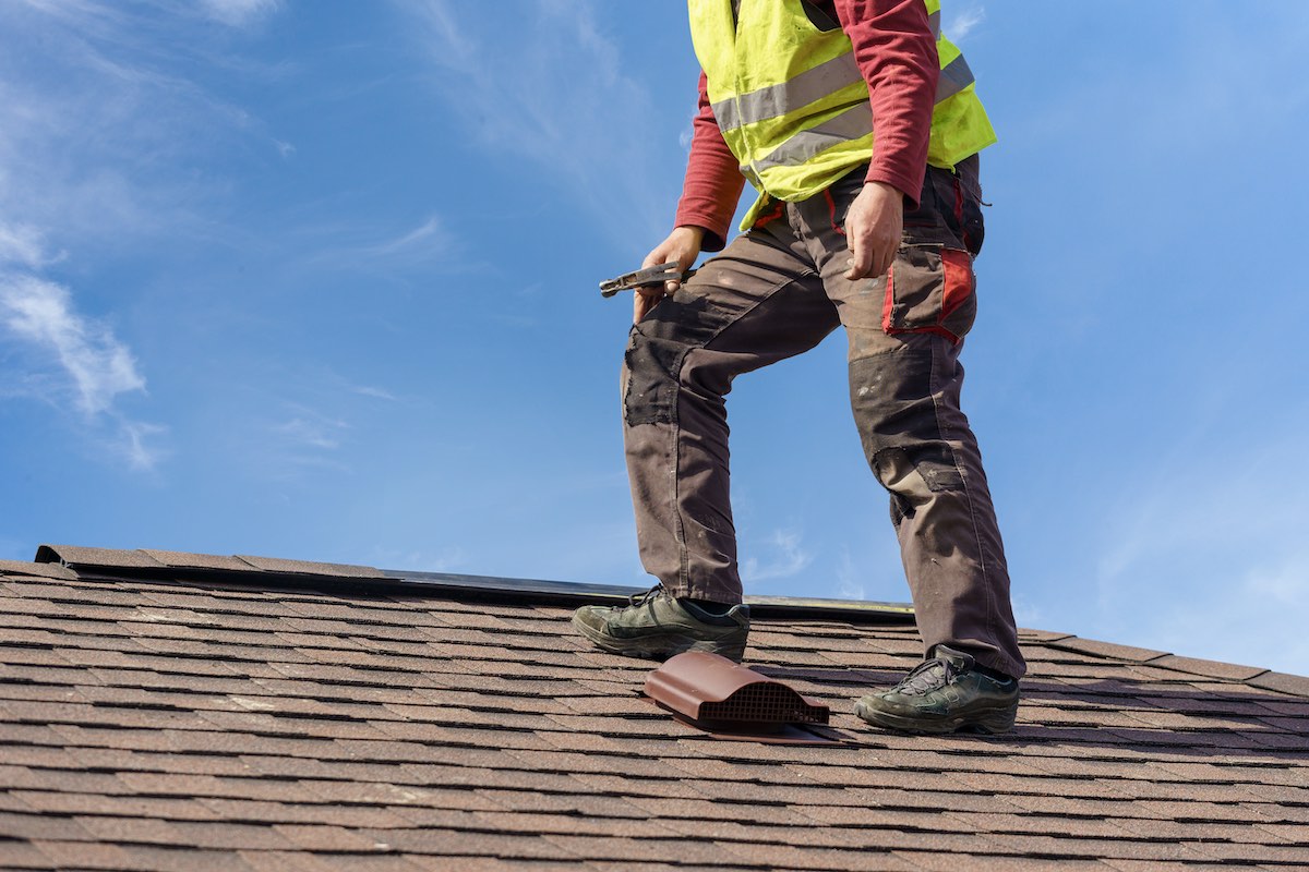 Houston roof expert climbing on roof to conduct a seasonal roof inspection in Cinco Ranch