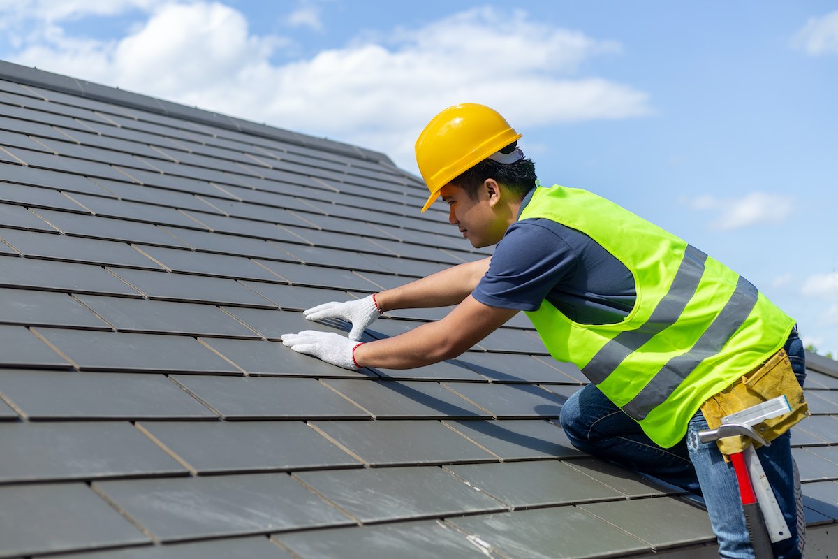 Houston roofer installing slate roof tiles