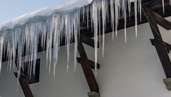 winter roof damage and icicles hanging from roof
