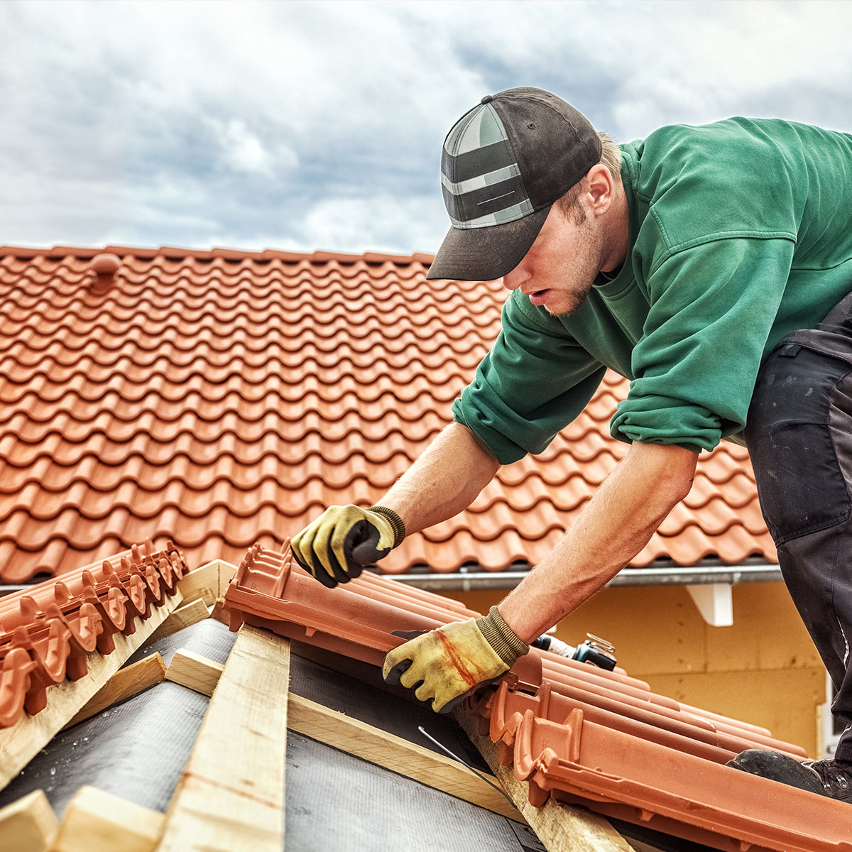A roofer installing shingles