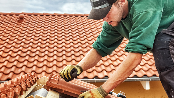A roofer installing shingles
