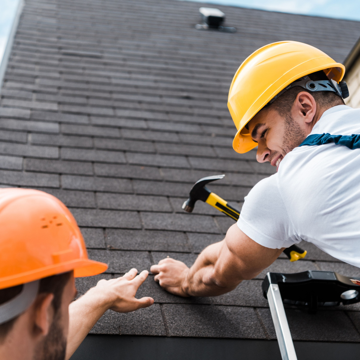 Two workers repairing a roof