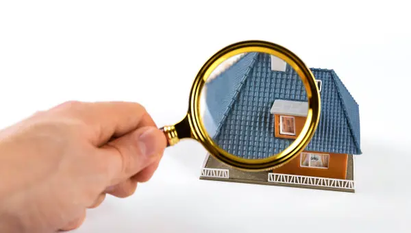 Magnifying glass held over roof to signify seasonal Piney Point Village roof inspection